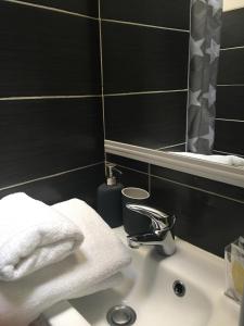 a bathroom with a sink with towels and a mirror at Résidence du Forum des Halles in Paris