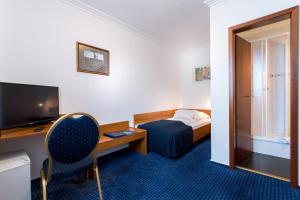 a hotel room with a bed and a desk and a television at Atlanta Budget Darmstadt in Darmstadt +14 photos