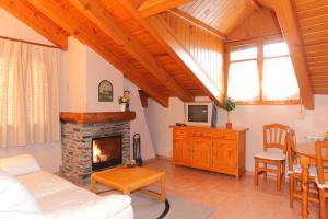 a living room with a fireplace and a table at Apartamentos Albá Casa Alquesera in Sahun