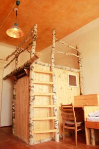 een speelhuis gemaakt van hout en een ladder bij Spirit Lodge Leipzig in Leipzig