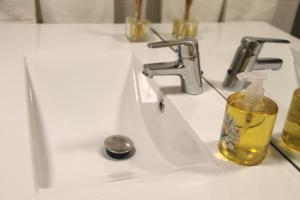 a bathroom sink with a bottle of soap on it at Five Elements Madeira in Funchal