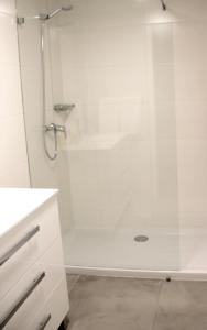 y baño con ducha blanca y puerta de cristal. en Five Elements Madeira, en Funchal