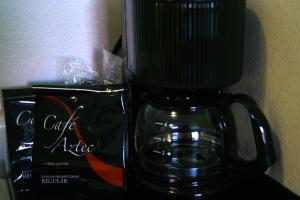 EloyにあるAmericas Best Value Inn-Eloy Casa Grandeのコーヒーメーカー(ガラスのマグカップの上に座る)