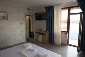 a bedroom with a white bed and a large mirror at La Marcu Pensiune in Tulcea +70 photos