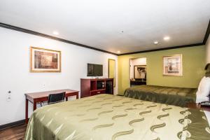 una camera d'albergo con 2 letti, una scrivania e un tavolo di Americas Best Value Inn Fort Worth a Fort Worth