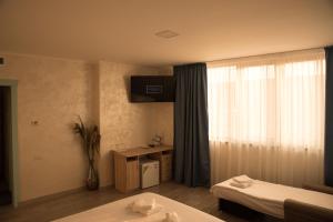 a hotel room with two beds and a window at La Marcu Pensiune in Tulcea