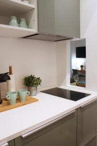 uma cozinha com um balcão branco e um lavatório em Milano Navigli Apartment - Via Tortona em Milão