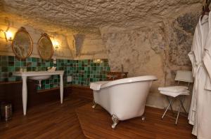 a bathroom with a bath tub and a sink at Logis Demeure de la Vignole in Turquant