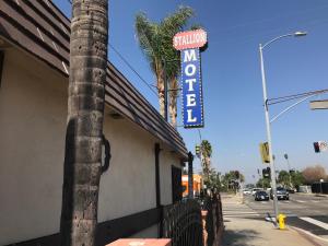 a sign for a restaurant on the side of a building at Stallion Motel Los Angeles in Los Angeles