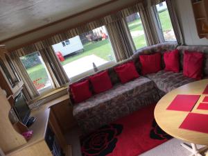 a living room with a couch and a table at Taylor's Caravan Holiday's 8 Berth (Coral Beach) in Ingoldmells