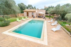 a swimming pool with chairs and a house at Ca'n Fosquet in Llucmajor