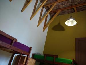 a room with a wooden table and a lamp at Hostel Brava mansa in Rosario