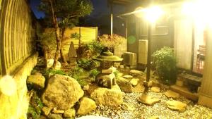 un jardín con una estatua en medio de un patio en Tsudoh Stay Hikoso, en Kanazawa