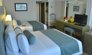 a hotel room with two beds and a desk at Best Western PLUS Gran Hotel Morelia in Morelia
