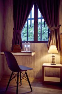 a chair and a lamp in a room with a window at LightHouse Hotel & ShortStay @ Damansara Uptown in Petaling Jaya