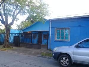 a blue house with a car parked in front of it at Hostal Casa Azul in Talca