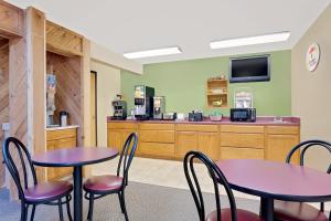 a restaurant with two tables and chairs and a counter at Super 8 by Wyndham Dyersville in Dyersville
