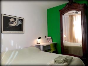 een groene en witte slaapkamer met een bed en een spiegel bij Sonia's Homestay in Rio de Janeiro