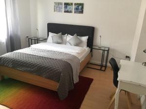 a bedroom with a large bed and a desk at A&H Apartment in Oberhausen