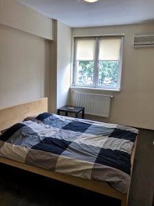 een slaapkamer met een bed en een raam bij Amzei Apartment Bucuresti in Boekarest