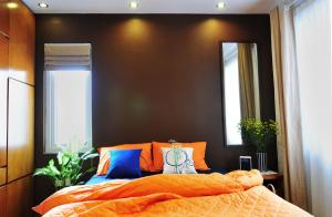 a bedroom with an orange bed and two windows at Chez Tram Homestay in Hanoi