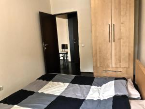 um quarto com uma cama com um edredão preto e branco em Amzei Apartment Bucuresti em Bucareste