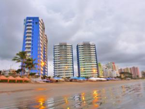 a group of tall buildings on a beach with umbrellas at Departamento Frente al Mar Diamond Beach in Tonsupa