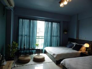 une chambre avec deux lits et une grande fenêtre dans l'établissement Woods Decor - Anping, à Tainan