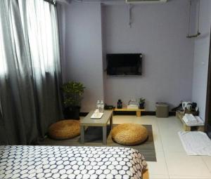 une chambre avec un lit et une télévision au mur dans l'établissement Woods Decor - Anping, à Tainan