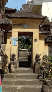 eine Tür zu einem Gebäude, zu dem eine Treppe führt in der Unterkunft Loris Homestay in Ubud