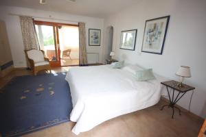 una camera da letto con un grande letto bianco con un tappeto blu di Can Alinda a Santa Eularia des Riu