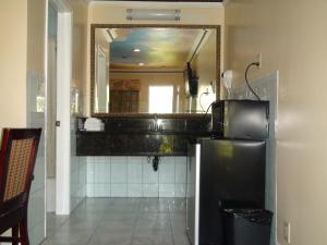 a bathroom with a mirror and a black refrigerator at Kearney Motel in Long Beach