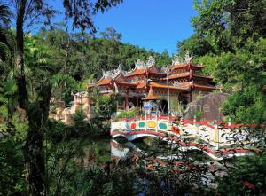 a temple in the middle of a river with trees at Pangkor Holiday Home in Pangkor