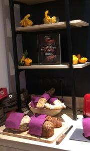 a shelf with a plate of bread and a book at Hotel-Restaurant Lann Roz / Côte Cuisine in Carnac