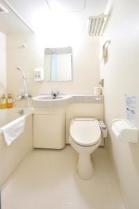 a white bathroom with a toilet and a sink at Fujieda Ogawa Hotel フジエダオガワホテル in Fujieda