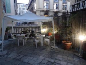 Tienda blanca y patio con mesas y sillas en Albergo Locanda Alambra, en Génova