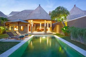 eine Villa mit Swimmingpool und ein Haus in der Unterkunft Mutiara Bali Boutique Resort & Villa in Seminyak