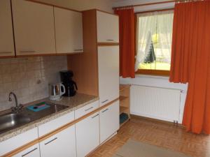 a kitchen with white cabinets and a sink and a window at Haus Schoderböck in Sankt Leonhard im Pitztal