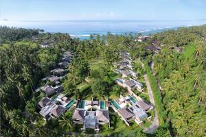 z góry widok na ośrodek z palmami i ocean w obiekcie Candi Beach Resort & Spa w mieście Candidasa