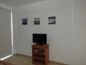 a room with a television and pictures on the wall at One Bedroom aptm Larnaca in Larnaka