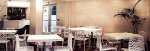 un ristorante con tavoli e sedie in una stanza di b&b lamaisondemary a Monteparano