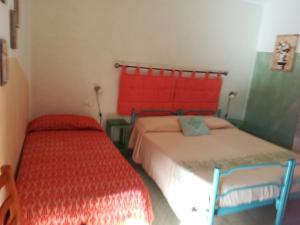 1 dormitorio con 2 camas y cabecero rojo en Agriturismo Ticci, en Seùlo