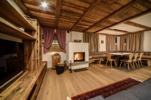 a living room with a fireplace and a dining table at Chalet Flierer in Rodengo