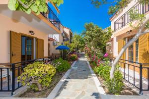 a walkway between two buildings with flowers at Christinantzela Apartments in Kokkari