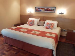 a hotel room with a large bed with pillows at Spurwing Guest House in Nairobi
