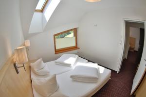a room with a white bed with pillows and a window at Lunaris Apart in Sölden