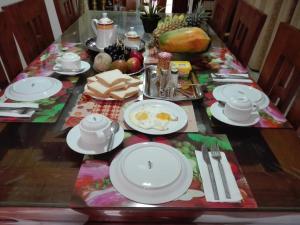 una mesa con platos y utensilios blancos. en Amara Guest en Mirissa