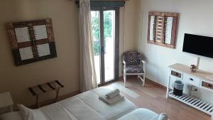 1 dormitorio con 1 cama, TV y silla en Hotel Marbel en Cala Ratjada