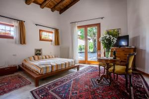 1 dormitorio con cama, escritorio y mesa en Agriturismo due Carpini, en Valdobbiadene