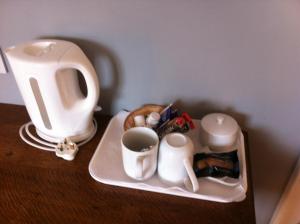einen Tisch mit einer Teekanne und einer Tasse Kaffee in der Unterkunft The Whitehouse in Dingwall